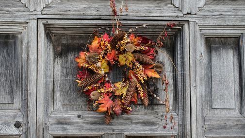 Autumnal wreath of red, yellow and orange leaves and pinecones